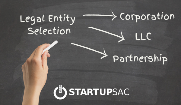 Image of chalkboard with a hand holding chalk and the works: Legal Entity Selection, it also shows StartupSac logo