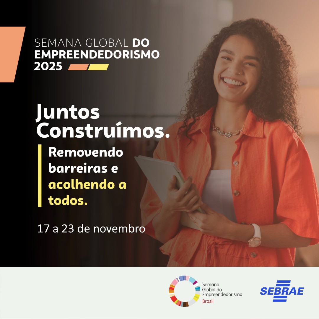A imagem é um card de divulgação da Semana Global do Empreendedorismo 2025, realizada pelo Sebrae. No lado direito, aparece uma mulher jovem, de pele morena, cabelos cacheados e soltos, sorrindo e segurando um tablet. Ela veste uma camisa alaranjada sobre uma blusa branca.  No lado esquerdo, sobre um fundo preto, está o texto: “SEMANA GLOBAL DO EMPREENDEDORISMO 2025” Logo abaixo, em destaque, lê-se: “Juntos Construímos. Removendo barreiras e acolhendo a todos.” Em seguida, há a data do evento: “17 a 23 de n