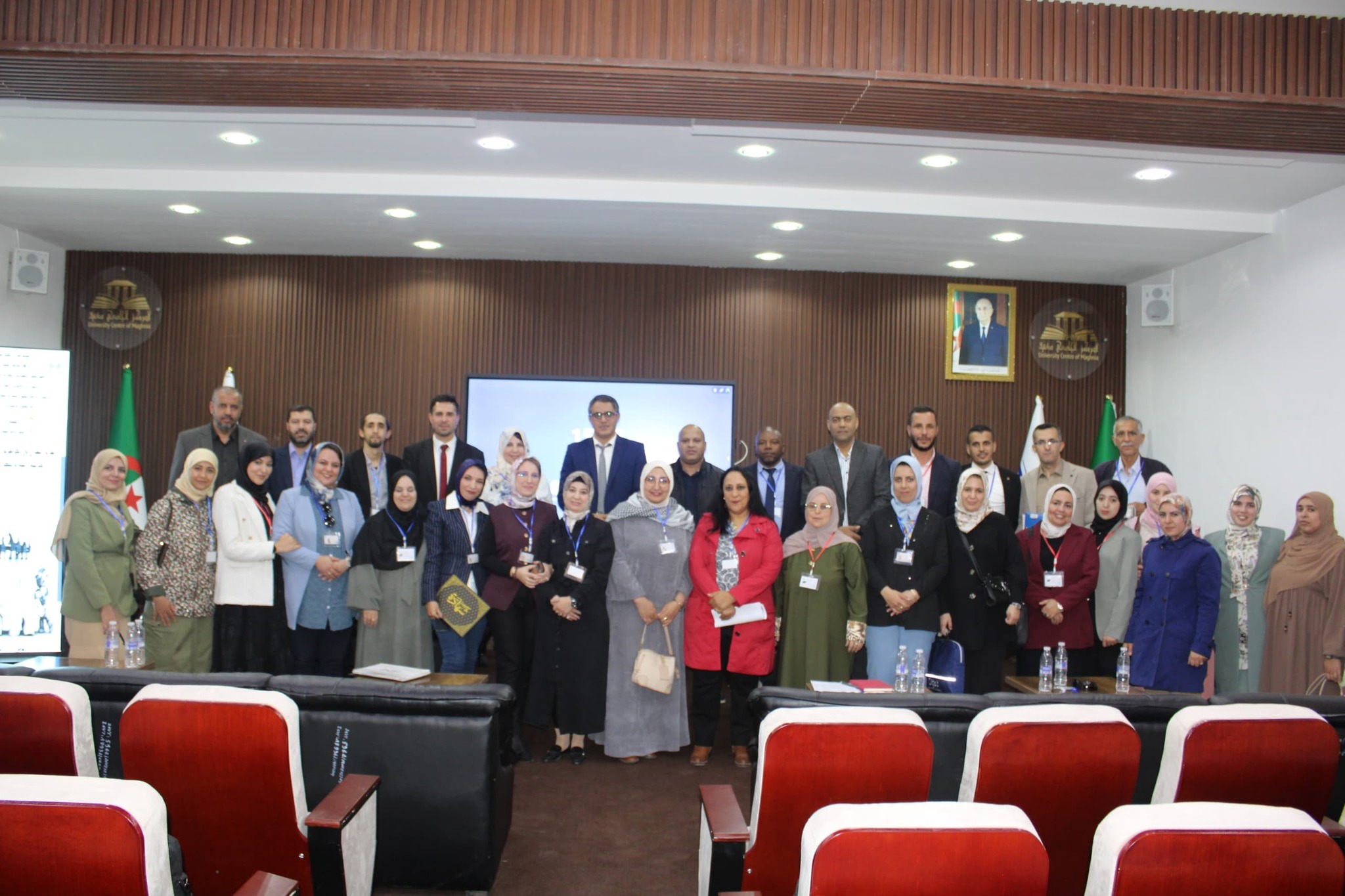 Group photo of participants in the national conference held at the Maghnia University Center, featuring faculty members, guests, and organizers at the conclusion of the event.