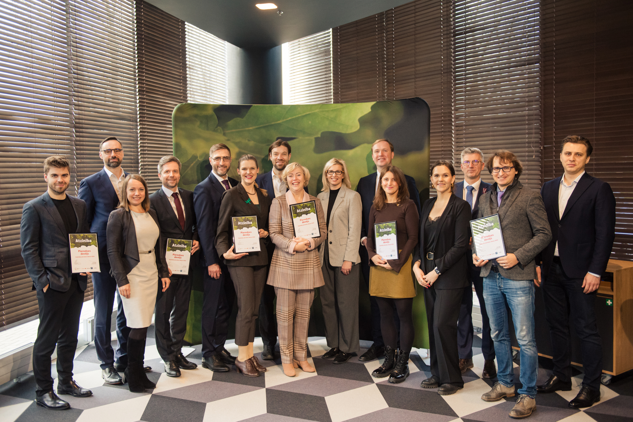 Group of people receiving letters of recognition from Minister of Economics of Latvia