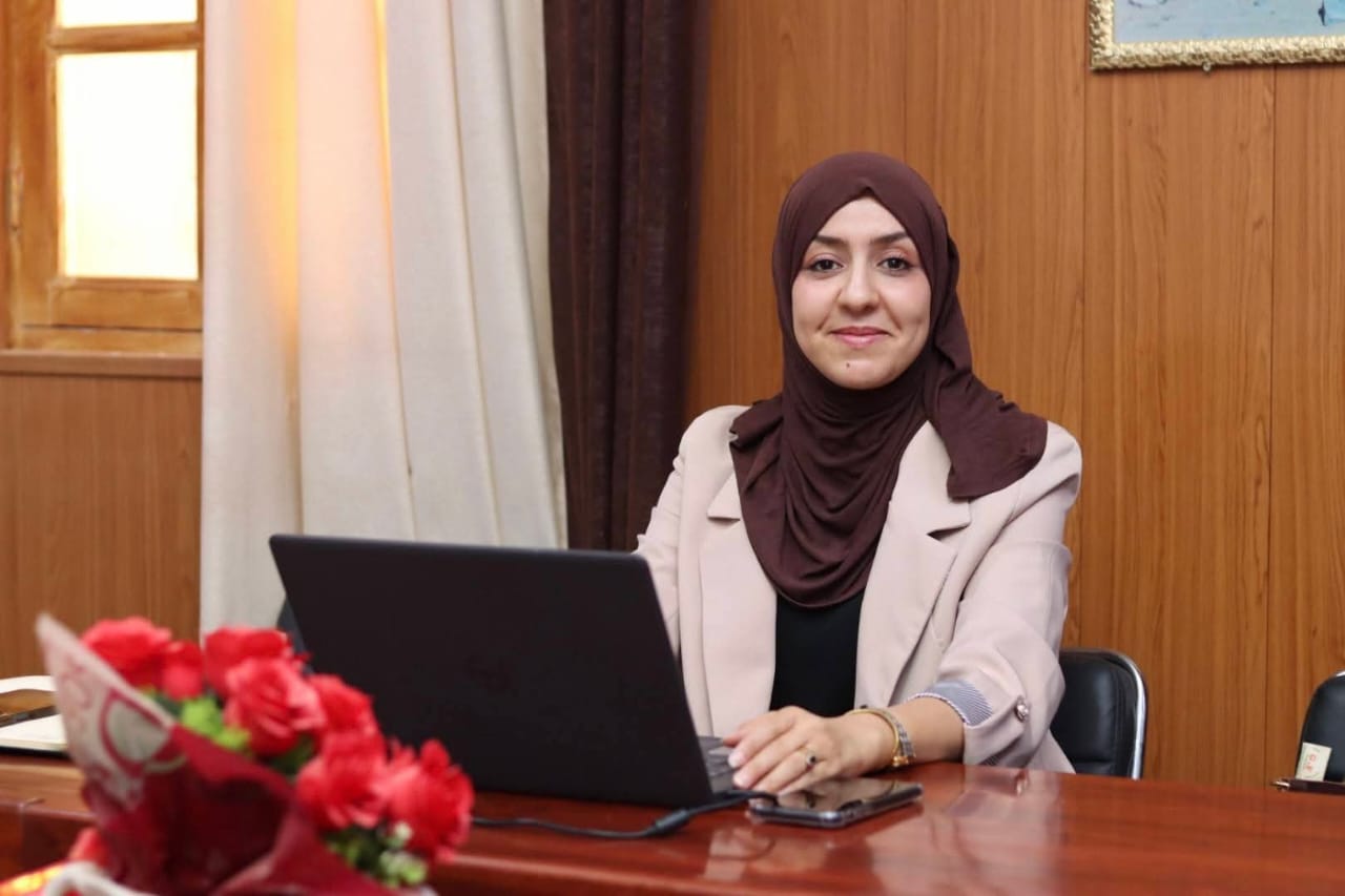 Image of the university interface representatives, institute directors, and deputy directors of the University Center of Illizi attending the coordination meeting to prepare the Global Entrepreneurship Week program, gathered around the table discussing upcoming activities.
