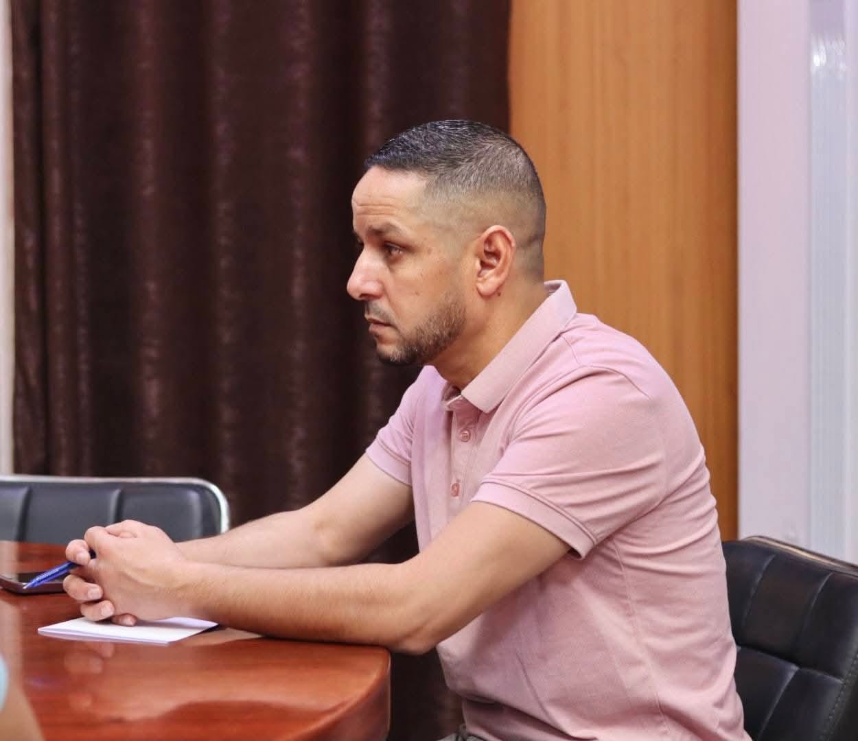 Image of the university interface representatives, institute directors, and deputy directors of the University Center of Illizi attending the coordination meeting to prepare the Global Entrepreneurship Week program, gathered around the table discussing upcoming activities.