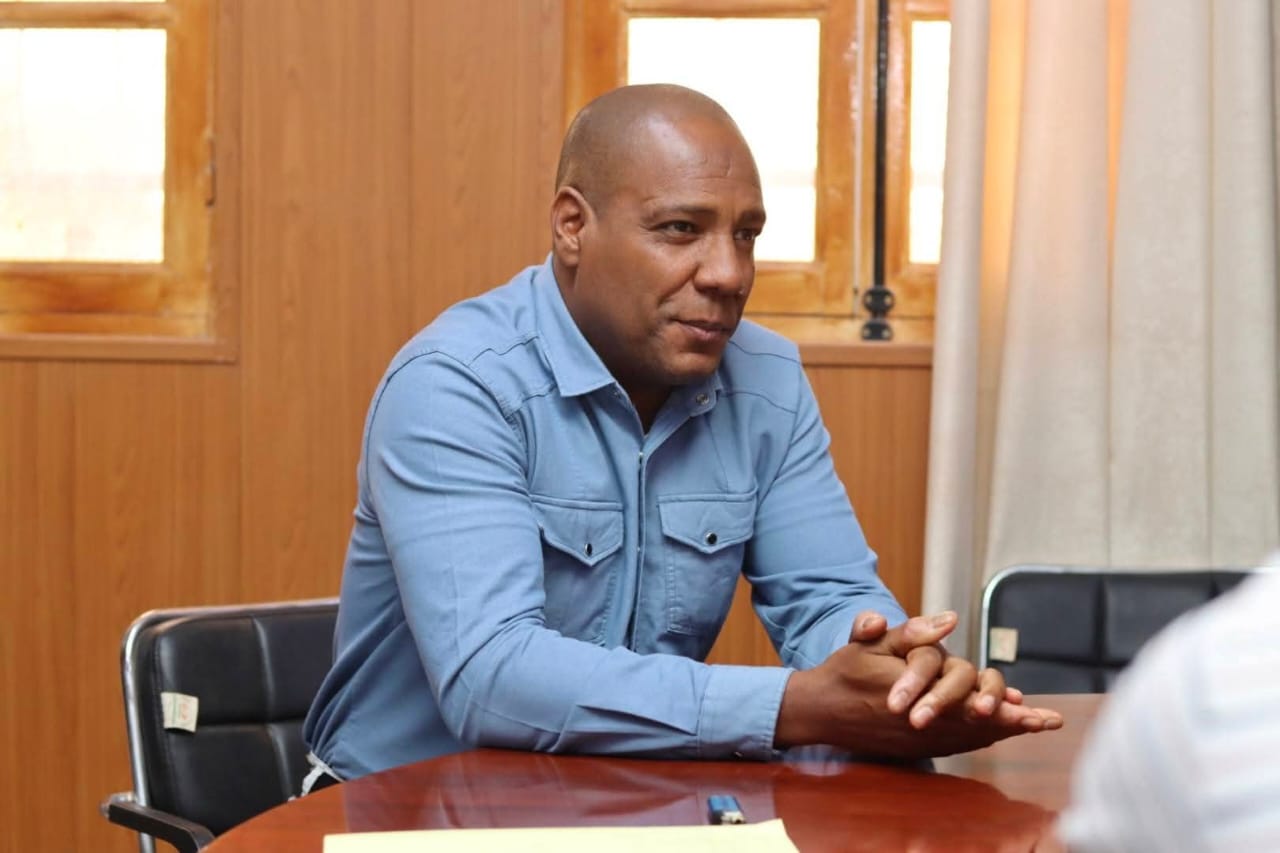 Image of the university interface representatives, institute directors, and deputy directors of the University Center of Illizi attending the coordination meeting to prepare the Global Entrepreneurship Week program, gathered around the table discussing upcoming activities.