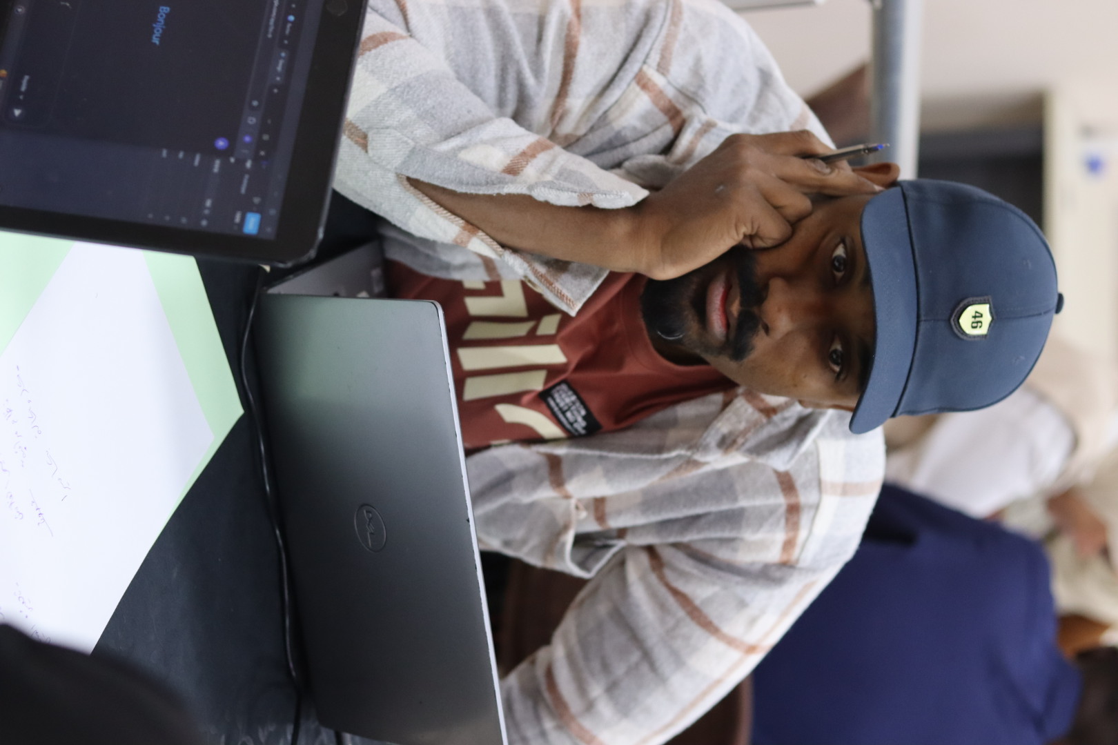 Image of a participating student in the Illizi Hackathon 2025, deeply focused while working on developing an innovative solution to the assigned challenge, within the collaborative environment of the coworking space.