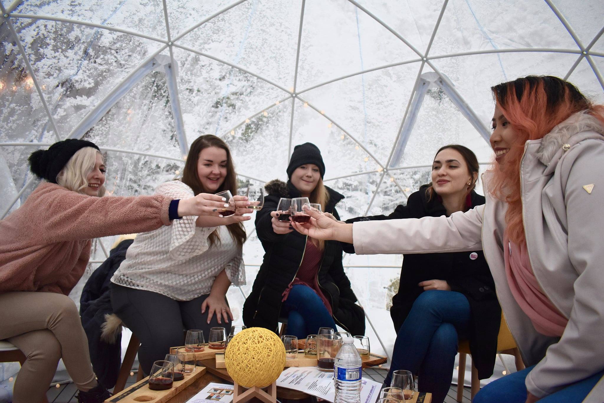 four ladies in an igloo drinking wine