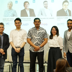 Four Asian men one Asian woman standing in front of white wall