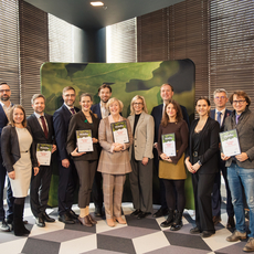 Group of people receiving letters of recognition from Minister of Economics of Latvia