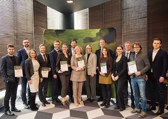 Group of people receiving letters of recognition from Minister of Economics of Latvia