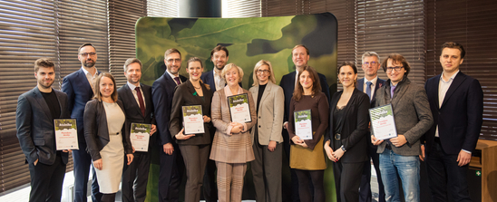 Group of people receiving letters of recognition from Minister of Economics of Latvia