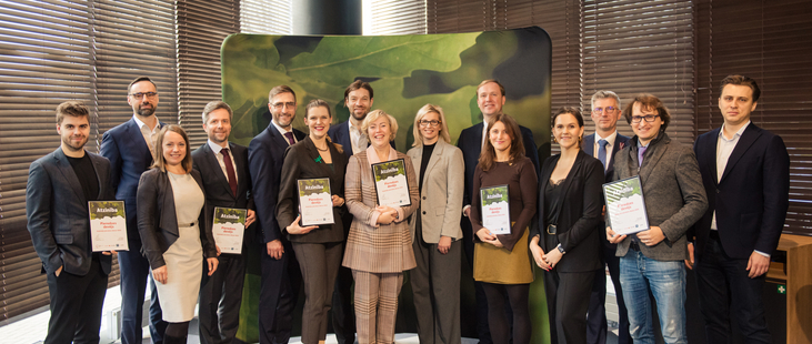 Group of people receiving letters of recognition from Minister of Economics of Latvia