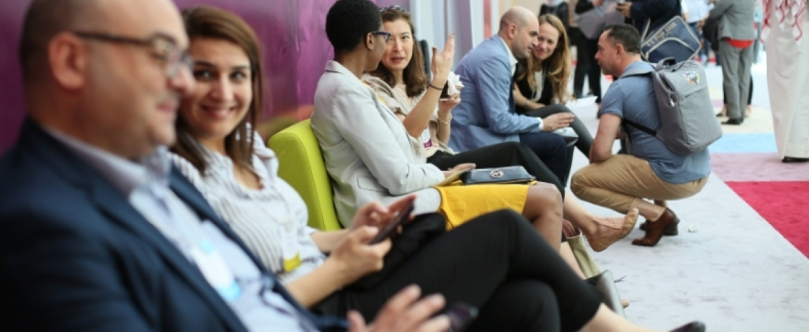 View of professional men and women sitting along a wall