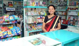 Woman selling at counter in a shop in rural India.